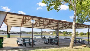 Un área de picnic techada con mesas de picnic y un letrero que indica la prohibición de recipientes de vidrio.