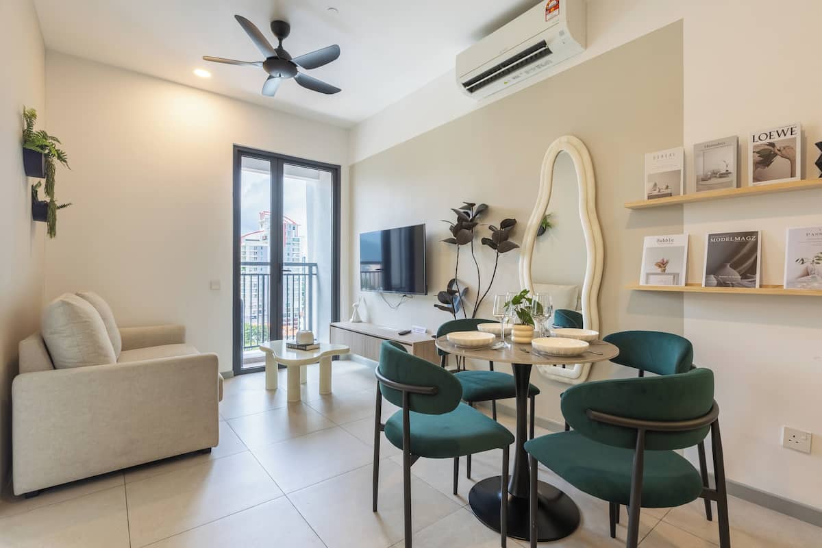 A modern living room with a sofa, dining table, chairs, and a TV.