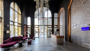 A spacious lobby with large windows, a reception desk, and modern seating areas. - 22 Macalisterz (George Town)