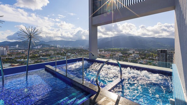 A rooftop infinity pool with a cityscape view, including mountains and buildings. - 22 Macalisterz (George Town)