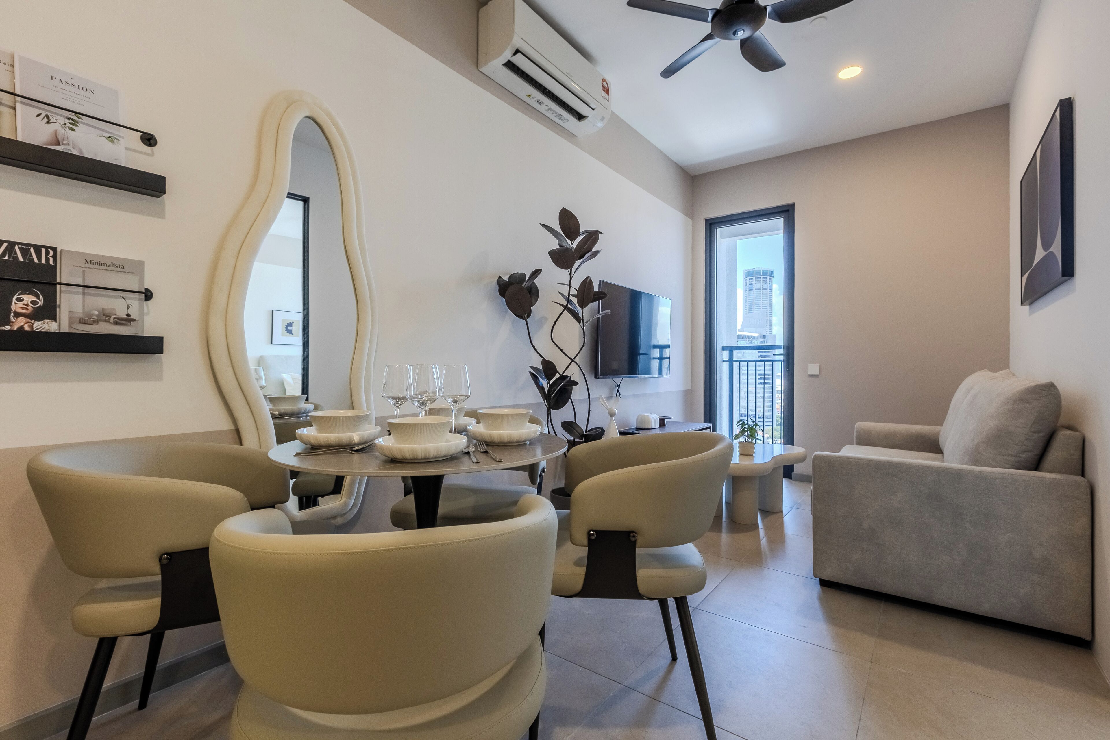 Un salon moderne comprenant un coin repas, un canapé, un téléviseur et un grand miroir.