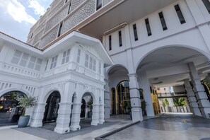 Ein weißes Gebäude mit mehreren Bögen und einem großen Eingang.