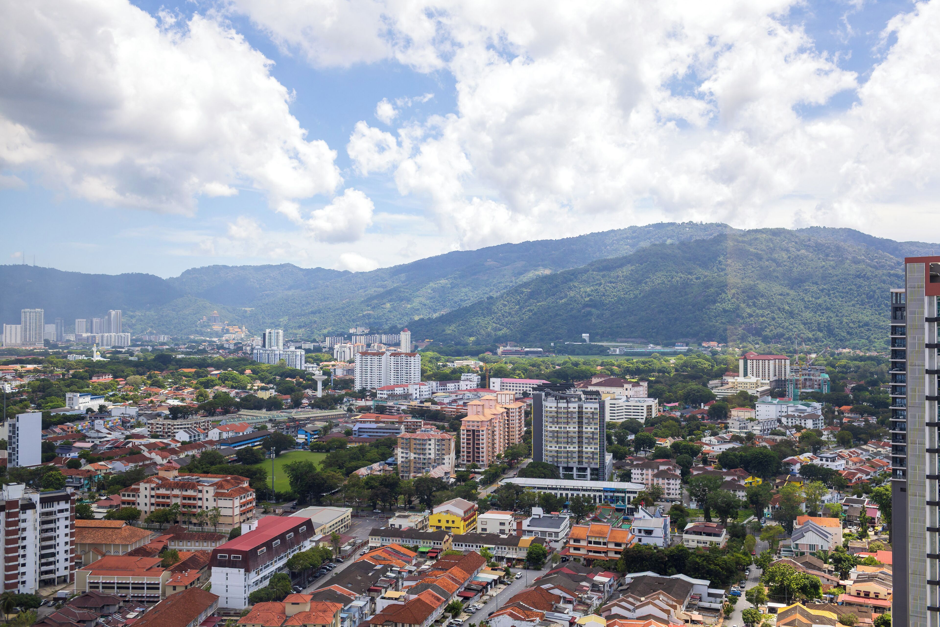 Eine Stadtansicht mit Gebäuden, Straßen und Bergen im Hintergrund.