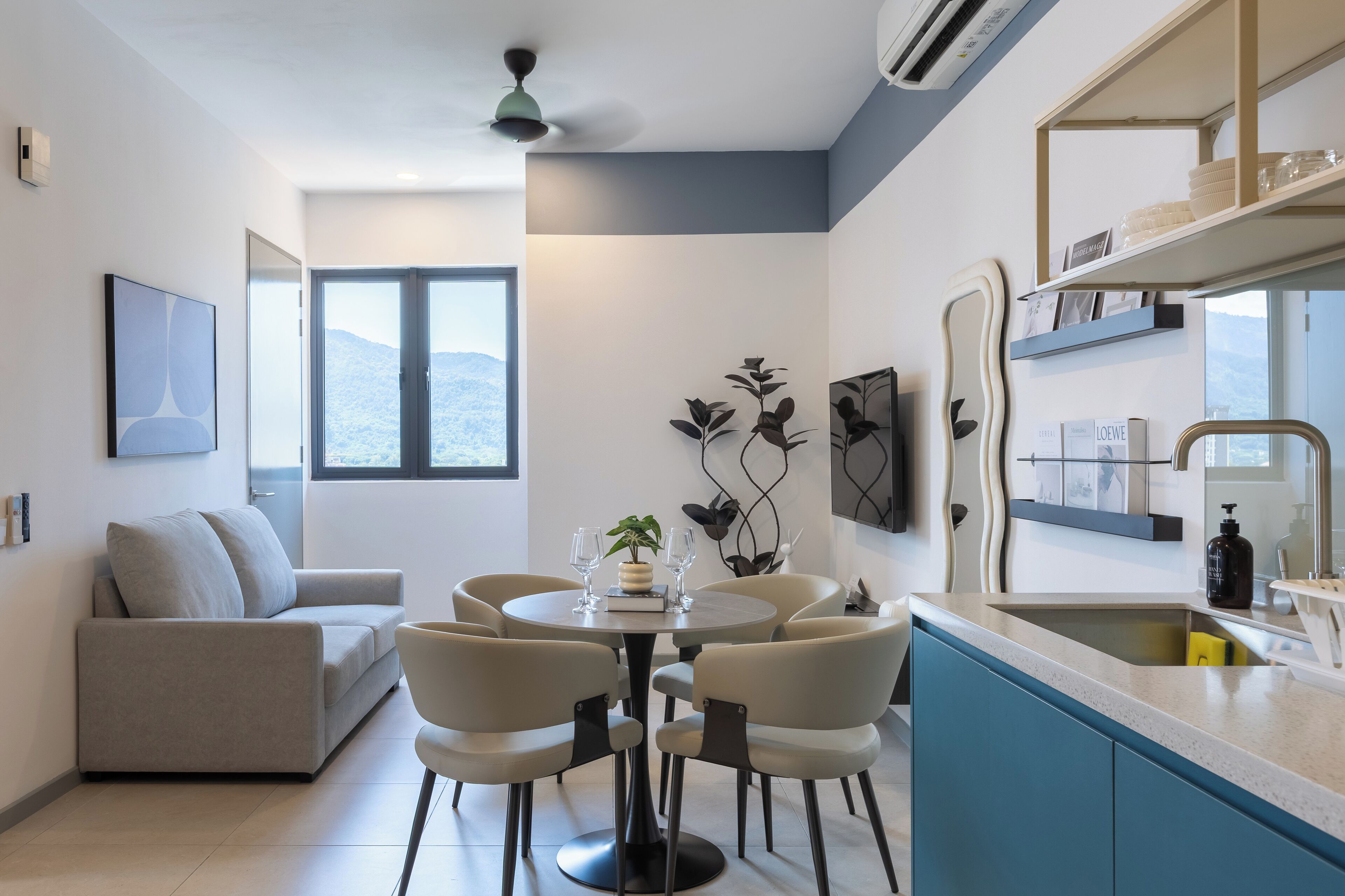Une cuisine moderne avec un coin repas, un canapé et une vue sur l’extérieur.
