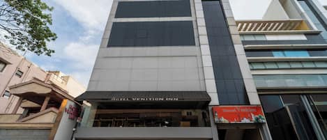 A modern hotel with a prominent sign reading "Hotel Vention Inn."