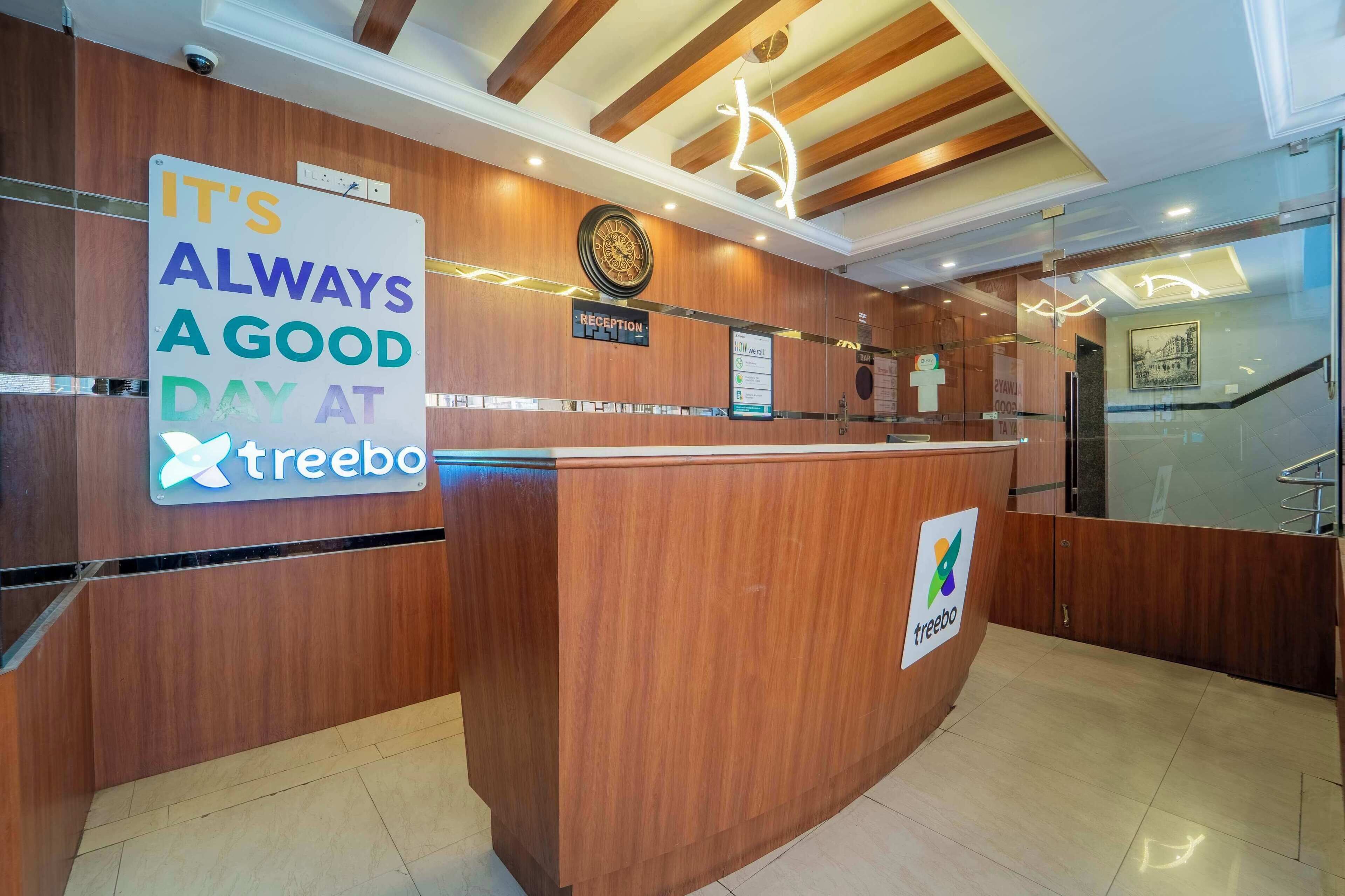 A reception desk with a sign that reads "IT'S ALWAYS A GOOD DAY AT treebo."