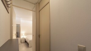 Una camera d'albergo con un letto, un comodino e un tavolino notte con una lampada.