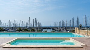 A swimming pool with a view of a marina and boats. - Entre Bateau et Mer by Interhome (Santo Stefano al Mare)