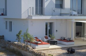 A modern two-story house with a balcony, outdoor seating area, and a fire pit. - Ginepro - Shelter by the sea in Apulia | A few steps from the beach (Puglia)