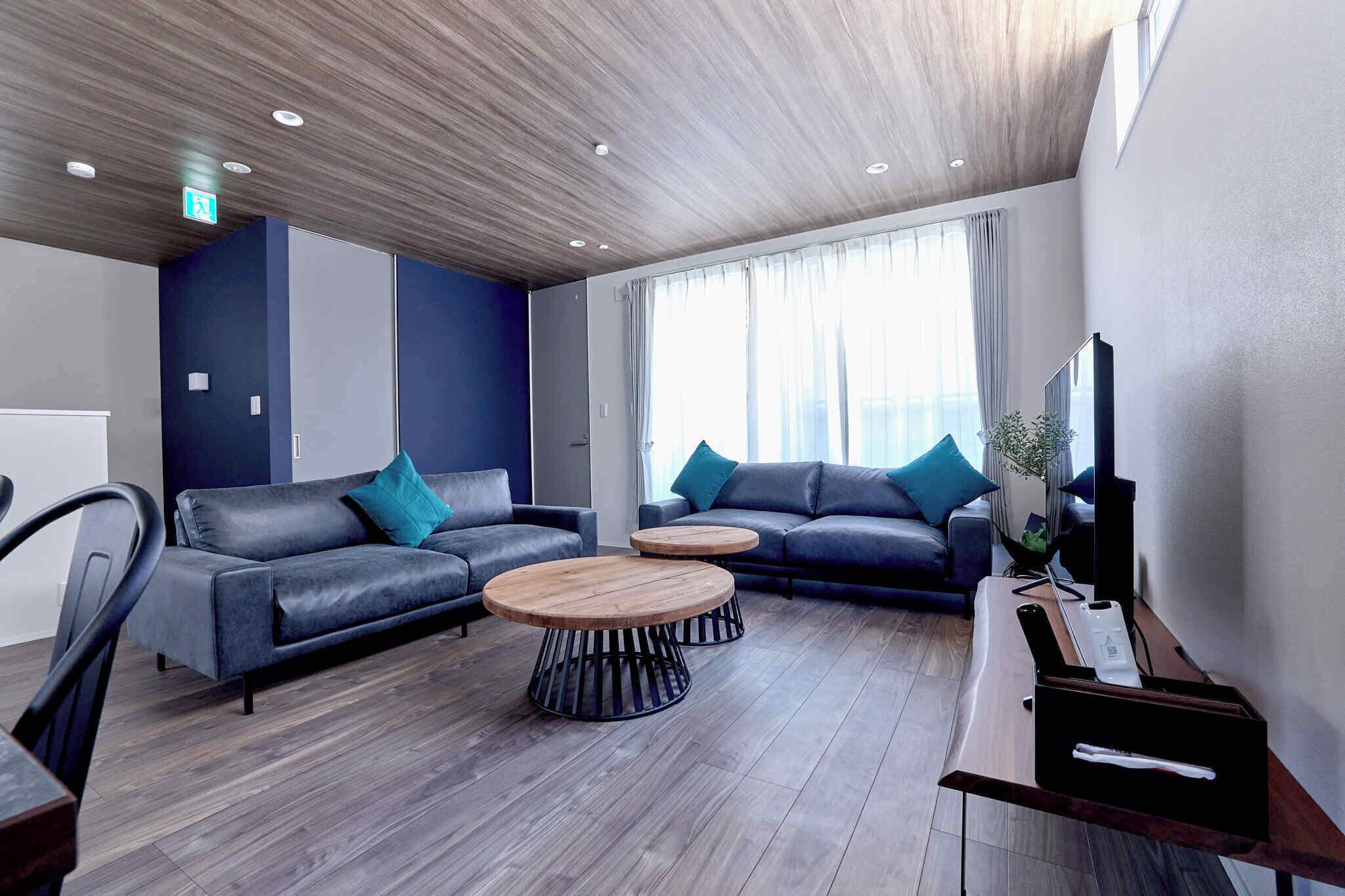 A modern living room with two sofas, a coffee table, and a TV stand.