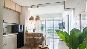 Una cocina moderna con un refrigerador negro, armarios de madera y una zona de comedor con una mesa redonda y sillas.