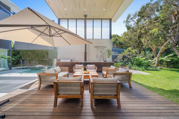 Relax and entertain outdoors with BBQ, fireplace, and lush garden views.