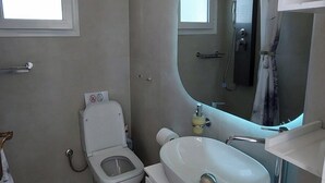 Ein modernes Badezimmer mit Toilette, Waschbecken und Spiegel.
