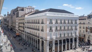 Un edificio histórico con arquitectura clásica, un patio central y una animada calle urbana.