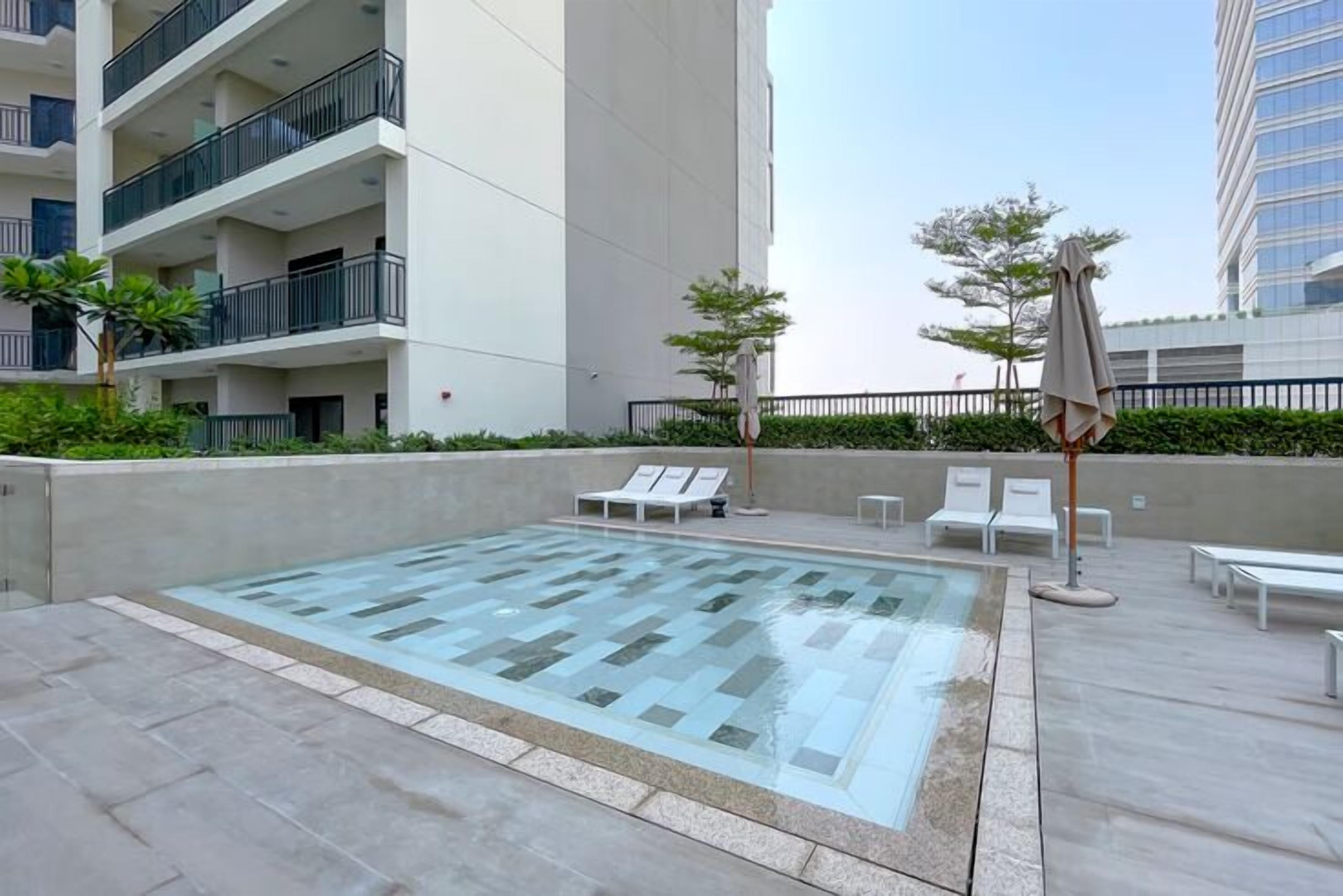 A rooftop pool area with lounge chairs and a glass-topped pool.
