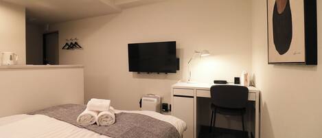 Espacio para trabajar con un portátil y tabla de planchar con plancha