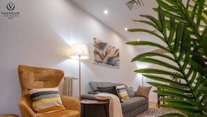 Una sala de estar moderna con sofá, sillón y lámpara de pie.