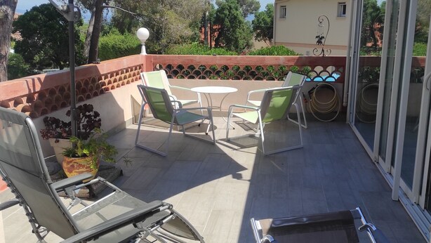 A patio with outdoor furniture, a large umbrella, and a view of the surrounding area. - Rent T2 a St Aygulf (St Aygulf)