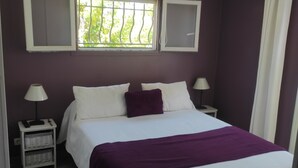 A bedroom with a bed, two bedside tables, a window with bars, and a ceiling light. - Rent T2 a St Aygulf (St Aygulf)