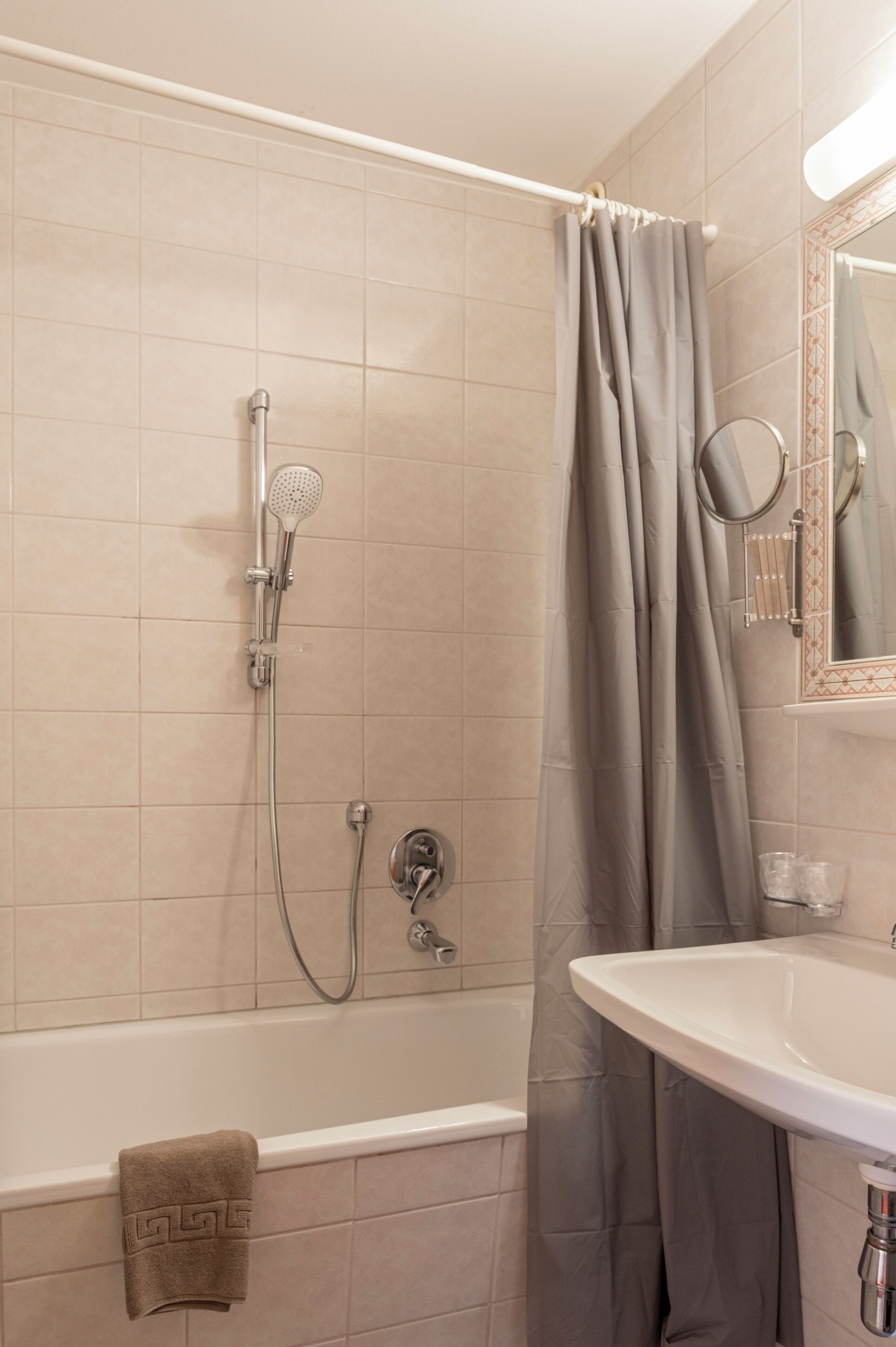 A bathroom with a bathtub, shower, and sink.