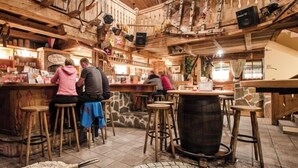A rustic bar area with wooden furniture and a large barrel. - Alpine B&B (Sankt Leonhard im Pitztal)