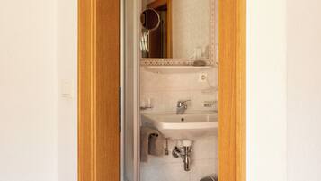 A bathroom with a sink, mirror, and toilet.