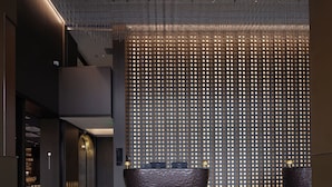 Un lobby moderno con techo alto, una recepción y una pared con diseño.
