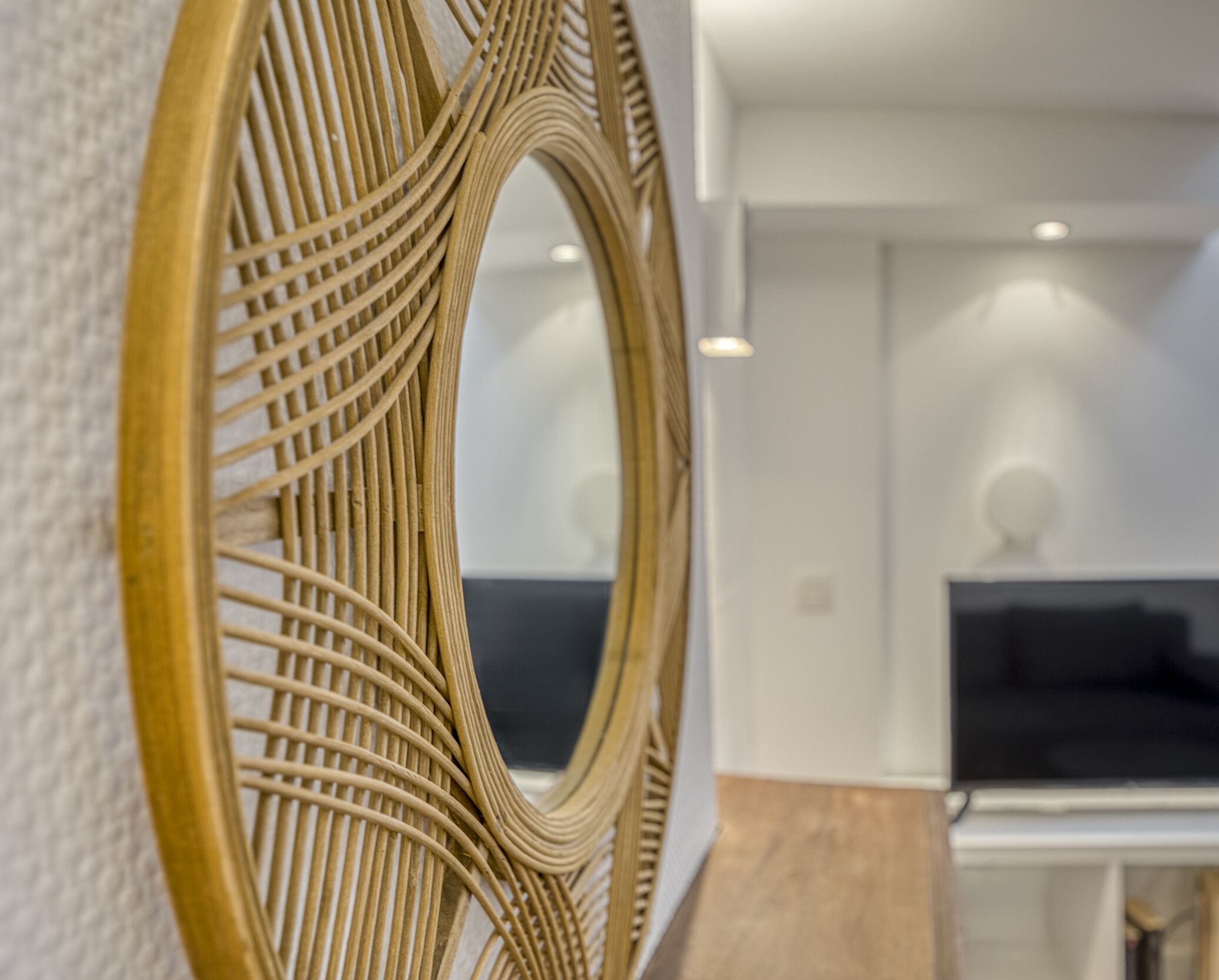Een modern interieur met een decoratieve spiegel en een zithoek.