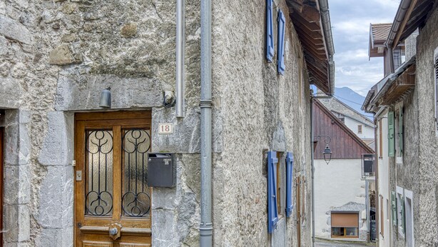 A narrow stone street with a wooden door and a mailbox. - Welcome to Les Volets Azur, a lovely fully renovated village house, ideal for a romantic getaway in the heart of Menthon-Saint-Bernard. Nestled between lake and mountains, this cozy home offers a peaceful and warm atmosphere. (Menthon-Saint-Bernard)