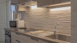 A modern kitchen with a stainless steel sink, a microwave, and a kettle.