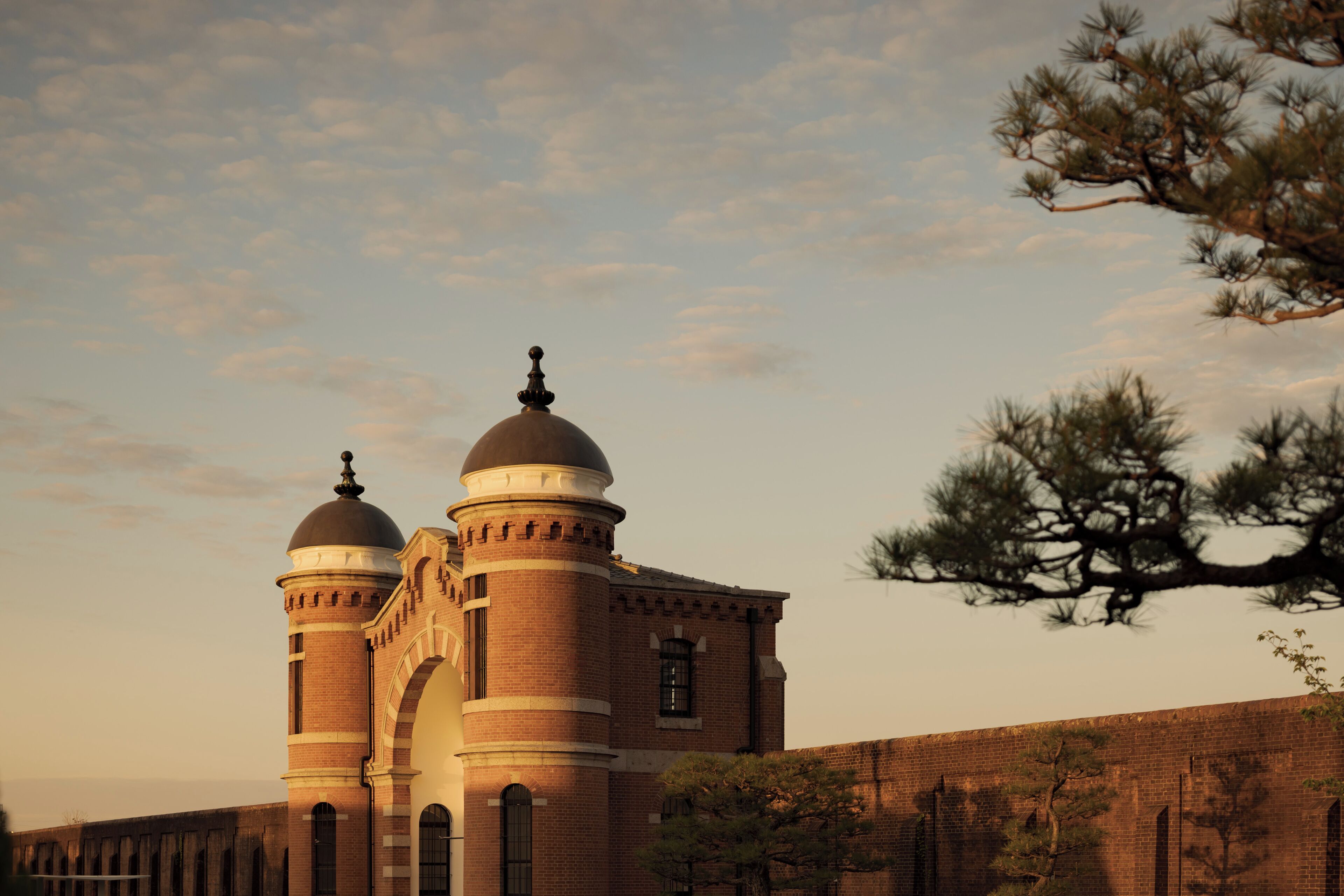 A large brick building with two domed towers and a prominent arched entrance.