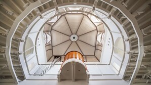 Un interior de varios niveles con una estructura central en forma de cúpula, varias escaleras y una serie de balcones.