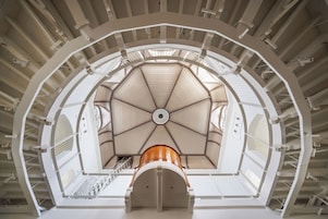 Un interior de varios niveles con una estructura central en forma de cúpula, varias escaleras y una serie de balcones.