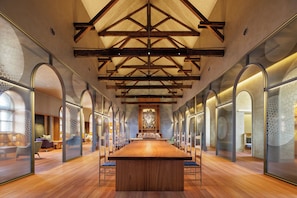 A spacious conference room with a long wooden table, high ceilings with exposed beams, and glass partitions with hexagonal patterns. - HOSHINOYA Nara Prison (Nara)