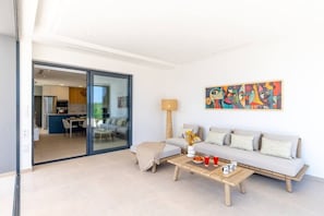 Una sala de estar moderna con un sofá, una mesa de centro y un cuadro en la pared.
