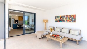 A modern living room with a sofa, coffee table, and a painting on the wall. - Dreamscape Villa by Fidalsa (Los Alcazares)