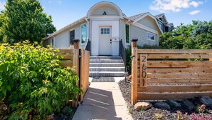 A two-story house with a white front door, a small porch, and a wooden gate with the number 2601. - Spacious Modern | Groups |Family |Sloans lake (Denver)