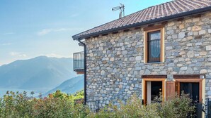 A stone building with a balcony, a door, and a window. - Lovely apartment for 3 people with WIFI, TV, terrace and panoramic view (Sorico)