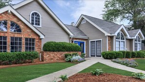 A two-story house with a brick facade, a blue front door, and a well-maintained lawn. - The Davis 1824 I Spacious 2 Bed 2 Bath (Huntsville)