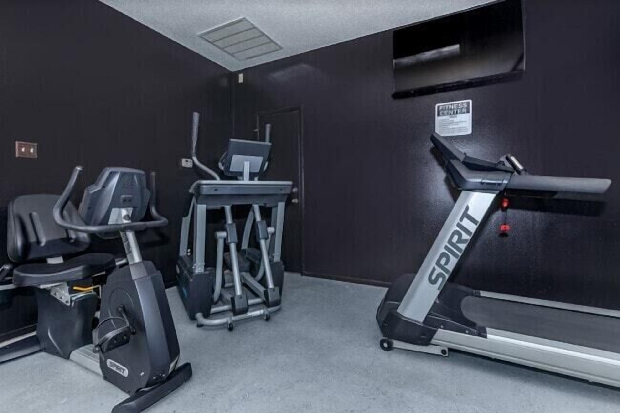 Ein Fitnessstudio mit Laufband, Crosstrainer und Kraftmaschine.