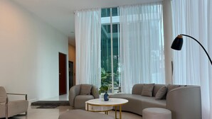 A modern living room with a sofa, a round coffee table, and a lamp. - myRoom at 11 J Adams (George Town)