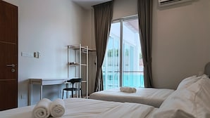 Une chambre d’hôtel avec deux lits, un bureau, une chaise et une vue sur l’extérieur.