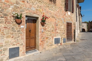 A stone building with a wooden door, two flower baskets, and a number '22' sign. - Apartment 'Piccolo Rustico' with Mountain View, Wi-Fi and Air Conditioning (Scrofiano)