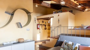 A cozy interior with a wooden table, a cactus plant, a staircase, and a bunk bed. - Apartment 'Piccolo Rustico' with Mountain View, Wi-Fi and Air Conditioning (Scrofiano)