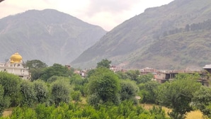 A mountainous landscape with a building featuring a golden dome. - Hotel Himalaya (Bhuntar)