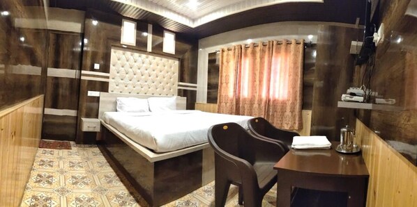 A hotel room with a bed, a desk, a chair, and a small table. - Hotel Himalaya (Bhuntar)