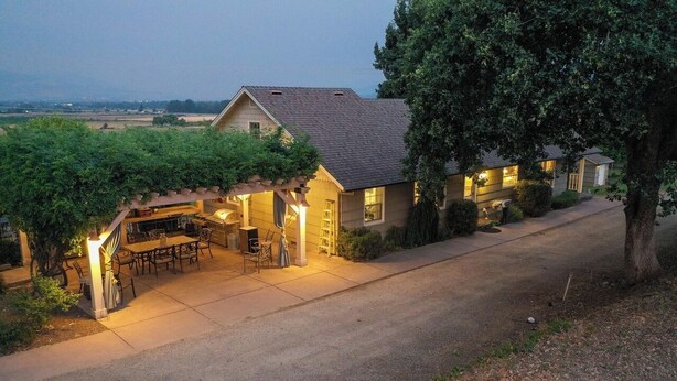 Een huis met een overdekte patio, een eethoek en een garage.