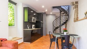 A compact living space with a kitchen, dining area, and a spiral staircase. - Charming duplex with private terrace in the heart of Avranches (Avranches)
