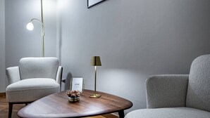 Un salon moderne avec un canapé gris, une table basse en bois et deux lampadaires.