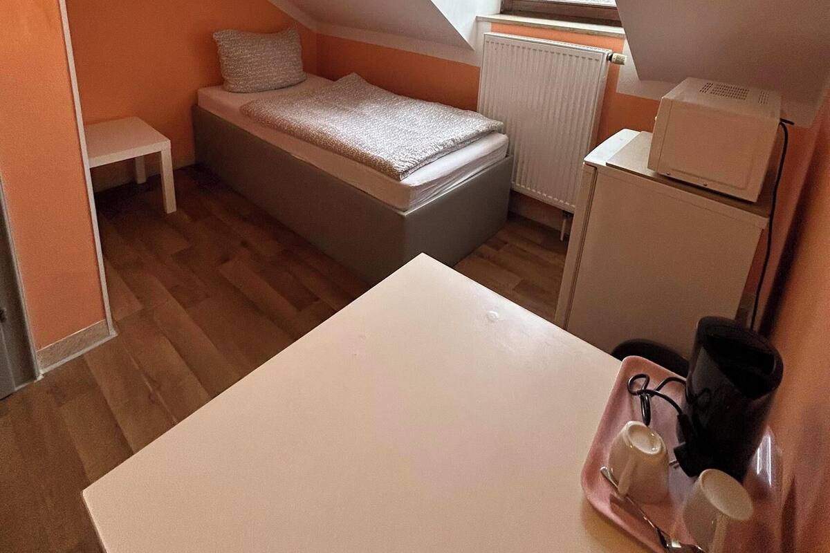 Une petite pièce compacte avec un lit en mezzanine, une petite table et un coin cuisine.